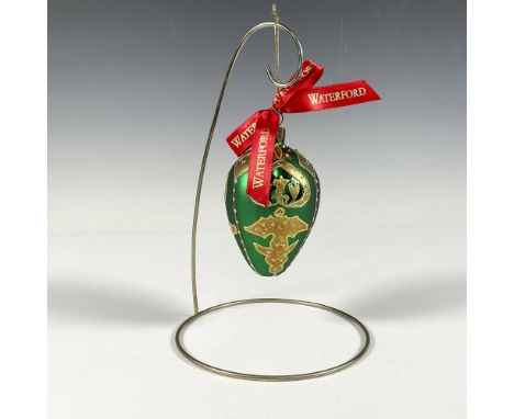 Handcrafted ornament adorned with gold decorative elements that include holly leaves and a stylized fleur de lis crown. The s