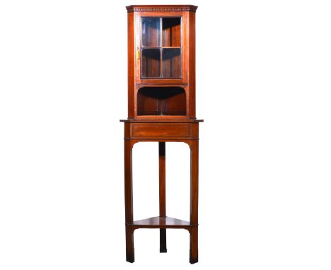 Edwardian walnut freestanding corner cabinet, a section with a cavetto and dentil moulded cornice, glazed door enclosing a sh