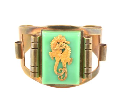 A 1930s Art Deco Hippocampe bangle retailed by JHP of Paris, and designed by Genevieve Hamon, the gilt metal bangle set with 
