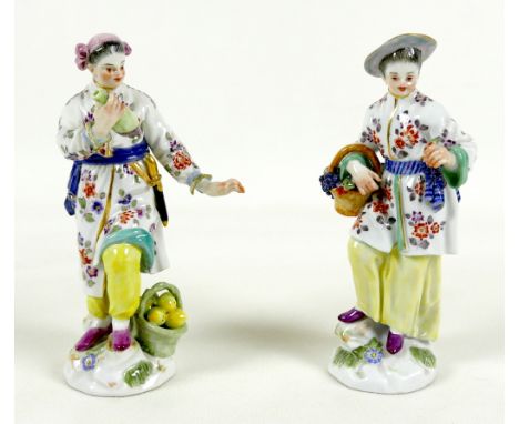 A pair of Meissen porcelain figures, early 19th century, modelled as fruit sellers, model numbers 65667, after the originals 