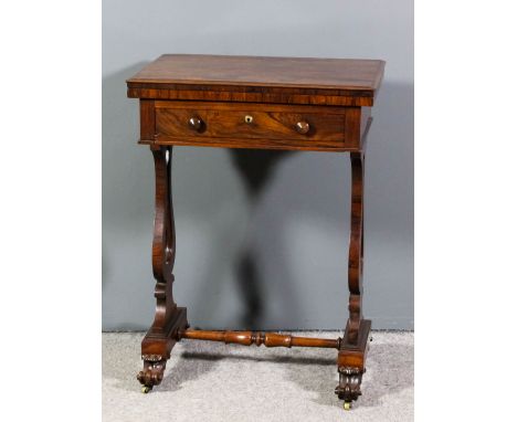 An early Victorian rosewood combined work and games table, the figured veneered top opening to reveal velour lined oval panel