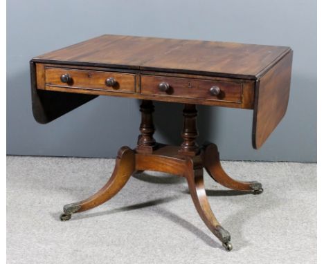 A George IV mahogany sofa table with D-shaped flaps, fitted two real and two dummy drawers, on twin turned central supports, 