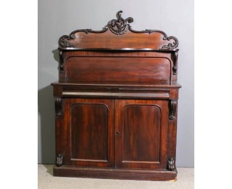 An early Victorian mahogany chiffonier, the upper part with carved and scrolled cresting, fitted single shelf, the base with 