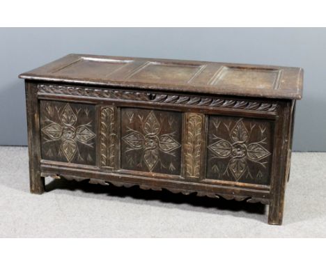 A late 19th Century panelled oak coffer with three fielded panels to lid, the front later carved with flowerhead and leaf orn