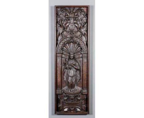 A 17th Century Continental carved oak panel with the standing crowned Virgin and Child within an architectural niche beneath 