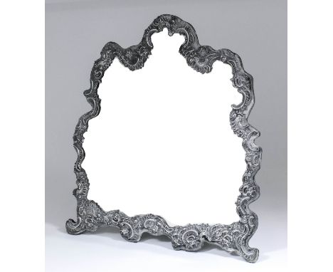 A late Victorian silver framed dressing table mirror of shaped outline, the silver pierced and embossed with leaf scroll and 