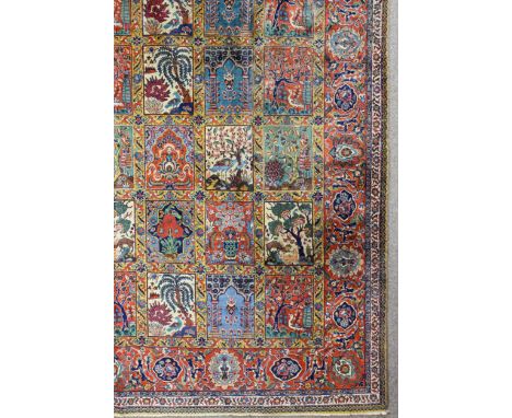 A Tabriz carpet woven in colours with seven rows each of eight rectangular tiles decorated with urns of flowers and birds and