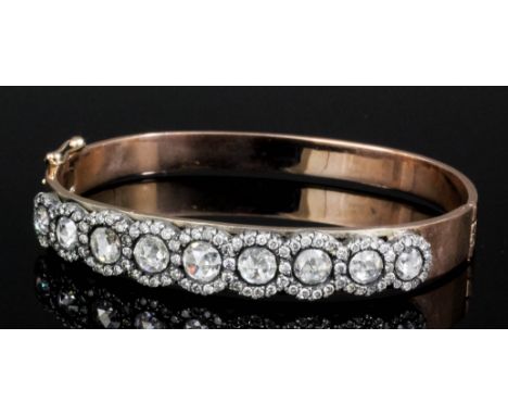 A 19th Century rose gold diamond set stiff pattern bangle, the face set with nine rose cut diamonds within rose cut diamond b