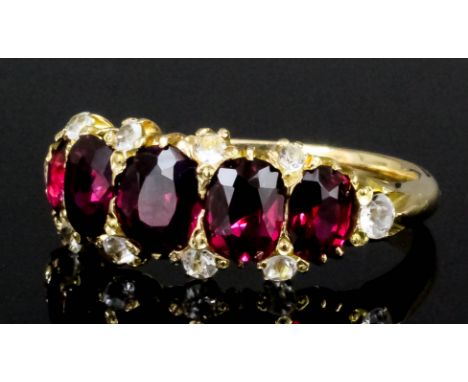 A modern gold coloured metal mounted ruby and diamond five stone ring, the five oval cut rubies (estimated weight 3ct) inters