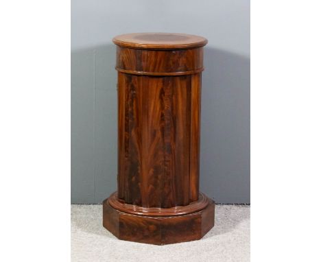 An early Victorian mahogany cylindrical pedestal cupboard with plain top and fluted sides, fitted one shelf enclosed by a sin