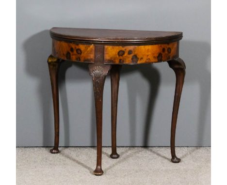 A 1920s figured walnut semi-circular card table of "Queen Anne" design, the baize lined folding top with deep frieze, on cabr