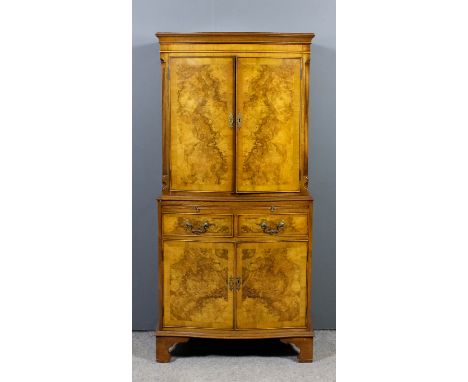 A modern Bevan Funnell figured walnut serpentine fronted cocktail cabinet of 18th Century design, the upper part with moulded