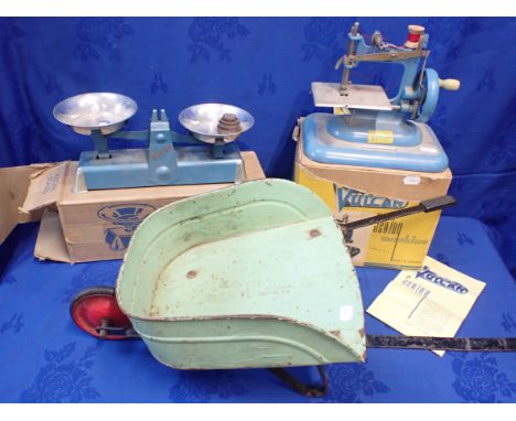 A VINTAGE 'VULCAN' TOY SEWING MACHINE (BOXED) (box damaged), a boxed set of Vulcan toy scales, and a toy metal wheelbarrow (3