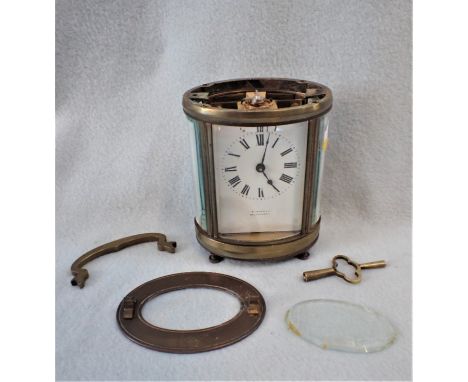 AN OVAL-CASED CARRIAGE CLOCK 12cm high (working, but the case in need of repair)
