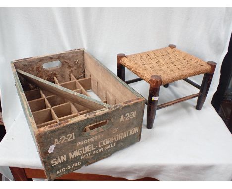 A VINTAGE SAN MIGUEL BOTTLE CRATE AND A WOODEN STOOL 