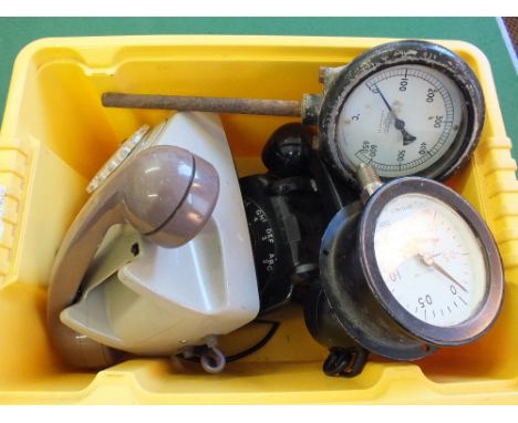 Black and grey telephones, an industrial thermometer and pressure gauges