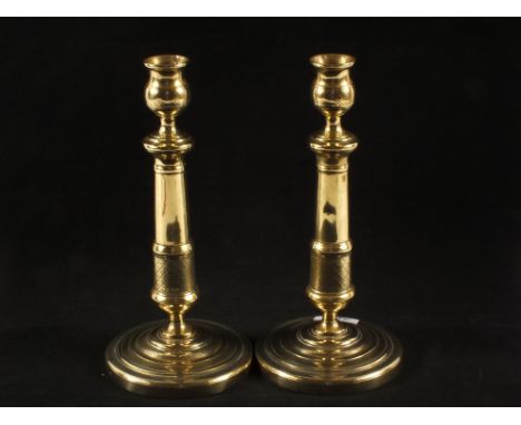 A pair of 19th Century French seamed Brass candlesticks with engine milled decoration on circular bases, 10 1/2" tall