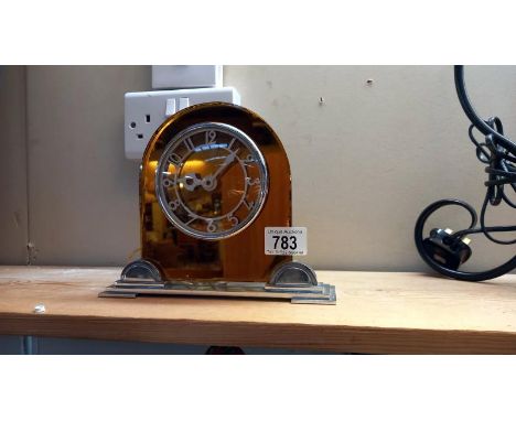 An art deco amber glass on chrome electric mantle clock 