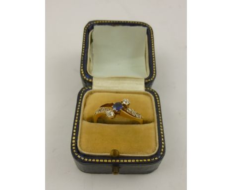 AN EDWARDIAN 18CT GOLD SAPPHIRE AND DIAMOND CROSSOVER RING having three stone head and shoulders each with four graduated cus