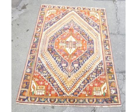 A SHIRAZ CARPET having multicolour floral and geometric forms on predominantly red and blue ground, 1.7m x 2.65m 