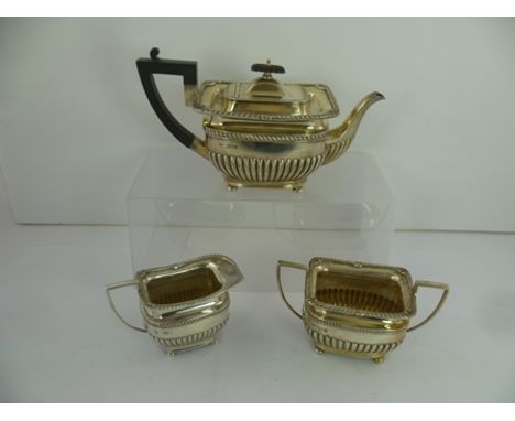 GOLDSMITHS & SILVERSMITHS COMPANY AN EDWARDIAN THREE PIECE SILVER TEA SET, Georgian rectangular form with gadrooned rims and 