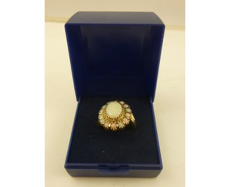 A GOLD COLOURED METAL AND OPAL MOUNTED CLUSTER RING having 15 stone head and split wire shank, stamped 375, size M1/2 