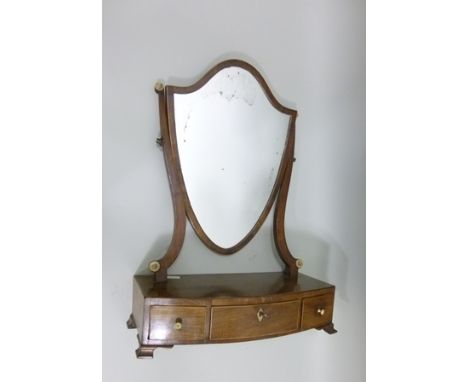 A PRINCIPALLY LATE 19TH CENTURY MAHOGANY TOILET MIRROR having crossbanded shield shaped plate, mounted on a box bow front bas