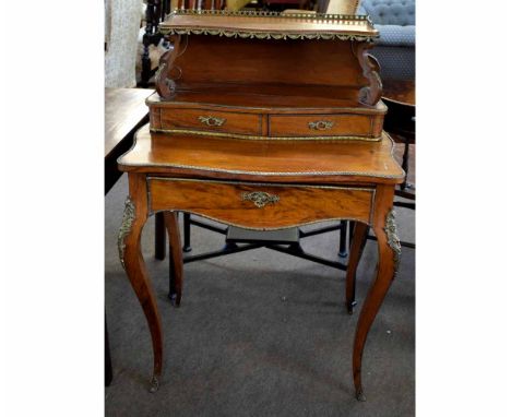 French kingwood and gilt metal ladies desk, with open shelf and galleried back, with scroll supports, fitted with two shaped 