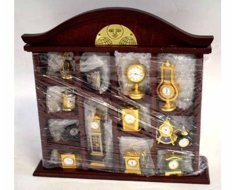Teak case containing 13 assorted miniature quartz clocks to include a mantel clock, alarm clock, anniversary clock etc, case 