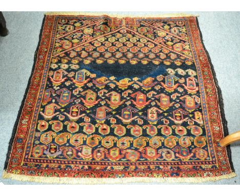 Rare Khomseh saddle rug, South West Persia, the deep indigo field of boteh beneath an arch flanked by spandrels and madder bo