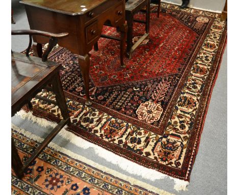 Abudeh carpet, South Persia, the deep red lozenge field with columns of stylised plants around an hexagonal medallion framed 