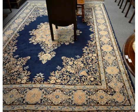 Kirman carpet, South East Persia, the deep indigo field centred by a pole medallion, the spandrels with urns enclosed by flor