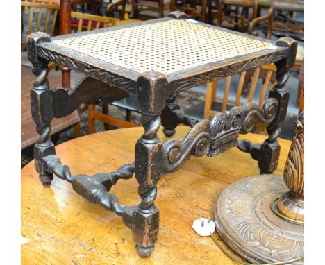 A 17th century carved oak stool with later cane seat