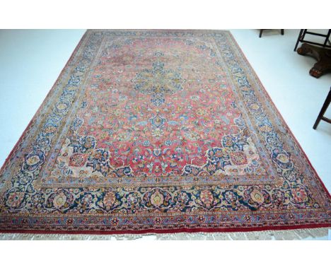 Kashan carpet, Central Persia, the faded raspberry field of palmettes and vines around a central medallion framed by spandrel