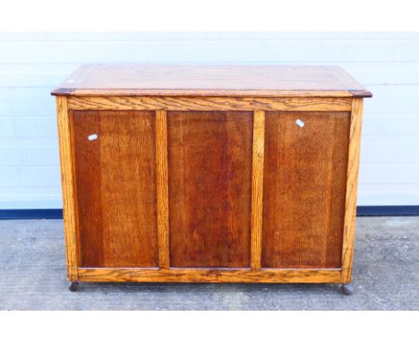 An oak blanket chest with three panel front and hinged top, approximately 68 cm x 95 cm x 47 cm. [W]