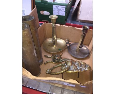 A small box of brassware to include door knockers and candlestick holders etc. 