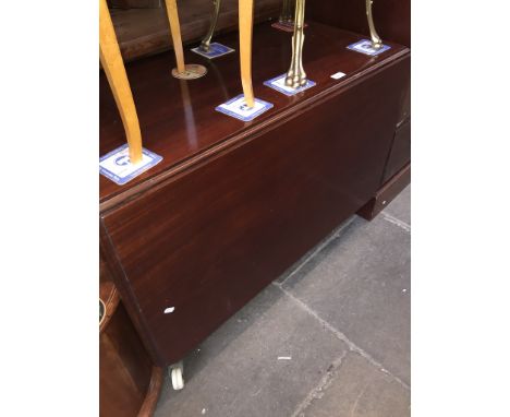 A mahogany drop leaf table on large ceramic castors 