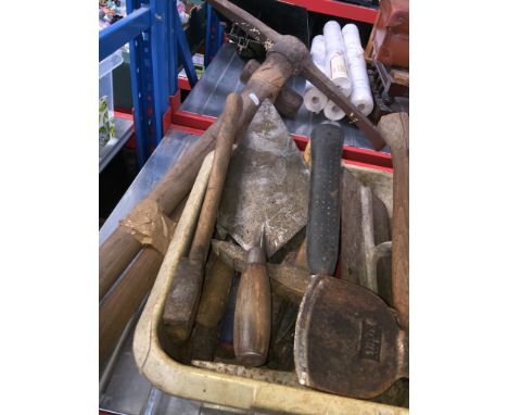 A box of bricklayers tools, a pick axe and a sledge hammer 