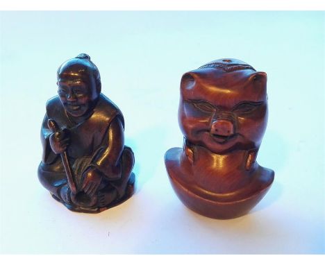 Two carved wooden netsuke, one in the shape of a pig and the other a seated oriental man (character mark to base)