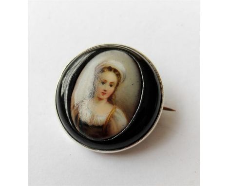 A 19th Century brooch set in silver metal, finely hand painted, depicting a portrait of a young girl, 13mm width x 20mm heigh