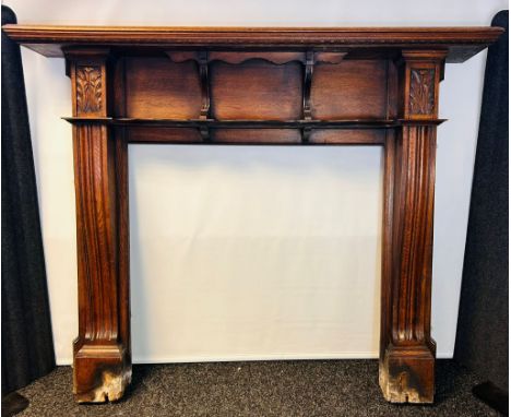 Carved oak fire surround, the moulded cornice above three open shelf compartments flanked by carved foliate design [143x1725x