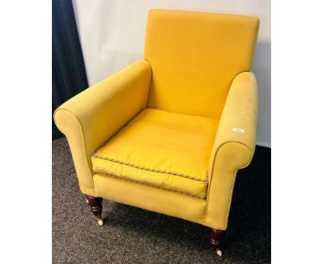 19th century arm chair, upholstered in a gold material, raised on turn tapered legs ending in ceramic castor feet
