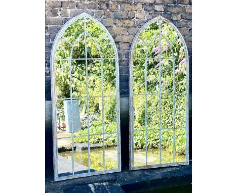 ARCHITECTURAL GARDEN MIRRORS, a pair, aged metal arched frames, 160cm x 70cm. 