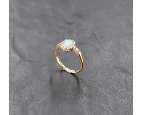 An opal and diamond chip cluster ring with diamond chip set angular shoulders on an 18ct gold loop, size R and approx 3.4g, (