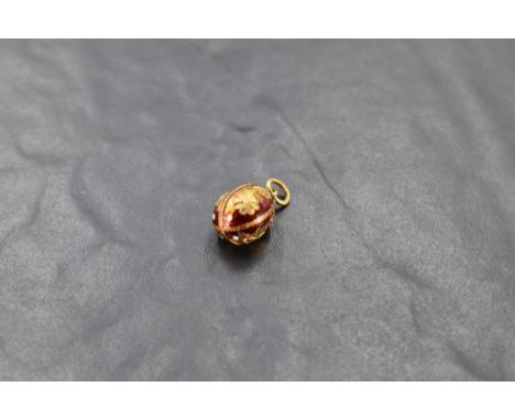 An enamelled yellow metal egg pendant stamped 750,  badly damaged and missing most of enamel, approx 3.2g