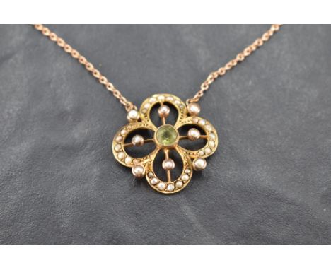 An Edwardian style yellow metal pendant stamped 9ct having central peridot with seed pearl decoration to open border on a fix