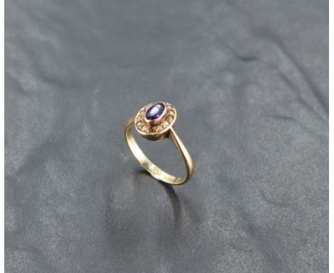 An oval amethyst ring having seed pearl surround in a collared mount on a 9ct rose gold loop, size N &amp; approx 2.4g (missi