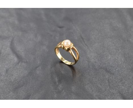 A yellow metal ring stamped 585 having a central cultured pearl to open shoulders&lt; size N &amp; approx 3.4g