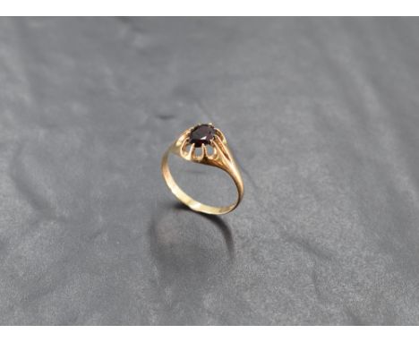 A 9ct gold and garnet gypsy type solitaire ring, with central oval-cut stone, the shank marked 375, ring size V, 2.4grams