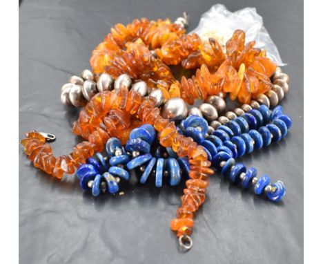 Two amber bead necklaces 141grams gross, a Lapis Lazuli bead necklace, a white metal bead necklace and pearl necklace.